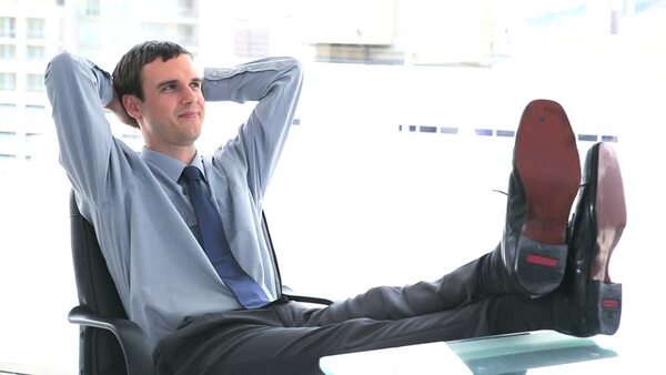 Felnőtt ember ül keresztezett lábbal egy szőnyegen, csukott szemmel és nyugodt testtartással